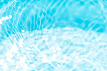 Blue water with ripples on the surface. Defocus blurred transparent blue colored clear calm water surface texture with splashes and bubbles. Water waves with shining pattern texture background.