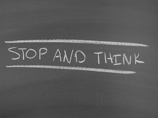 Stop and think written on a chalkboard surface as conceptual advice