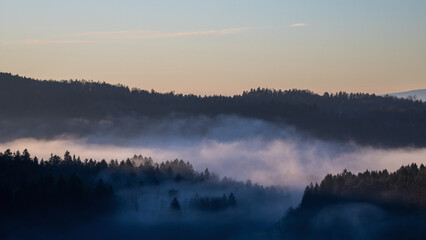 Fototapeta premium Early morning foggy sunlight mood above a valley