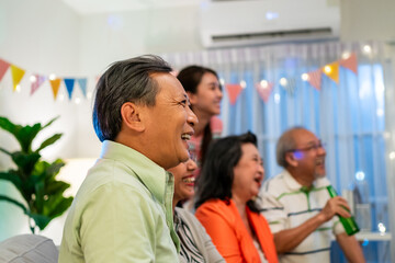 Group of Asian senior friend having evening party in living room at home.