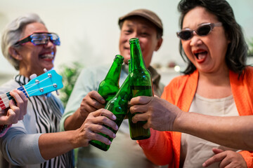 Group of Asian senior friend having evening party in living room at home. 