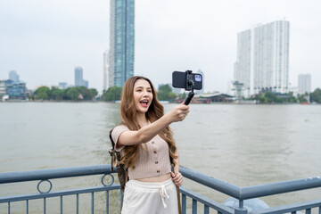 Asian beautiful woman backpacker taking a selfies outdoors in the city.