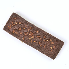 Decadent chocolate brownie with nut pieces resting on a white surface, perfect for dessert cravings after a meal