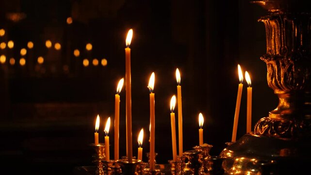 burning candles in church in the dark, church canon place where many candles burn, christian holidays concept