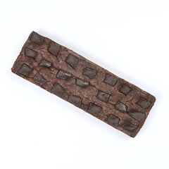 A rich chocolate brownie topped with chocolate chunks is presented on a clean white surface at a casual dessert gathering in the afternoon