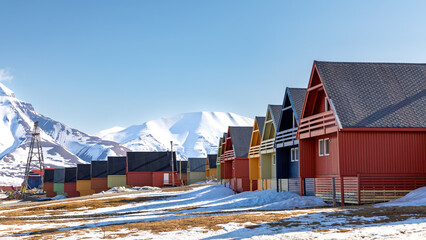 Row of colourful wooden houses in Longyearbyen, Svalbard, the most northerly town in the world. Early spring scene with snow on the mountains and the foreground © Rixie