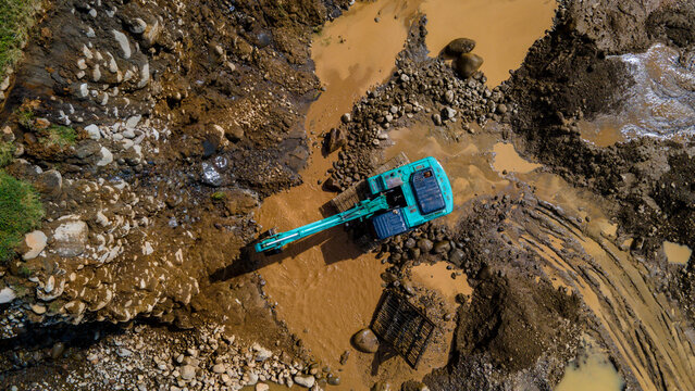 Excavator and dump truck working in rock and sand mine, Construction and mining site view from above.