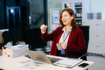 Confident businesswoman working on a laptop at a sleek office desk, showcasing professionalism, productivity