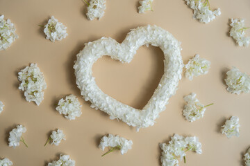 Symbol of love beautiful flower petals in heart shape in beige background. Creative concept of St Valentines day, weeding romantic date or anniversary. Copy space greeting card