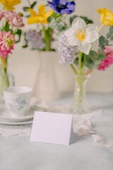 Mockup card on Elegant Breakfast Table Setting with Spring Flowers in Soft Tones