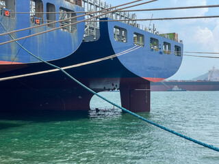 Two large container ships docked side by side at the aft stations in a Chinese repair yard. Static wide shot showing industrial maritime activity, ship maintenance, and global trade infrastructure.