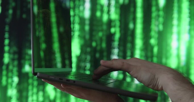 Type something on the laptop with a matrix background