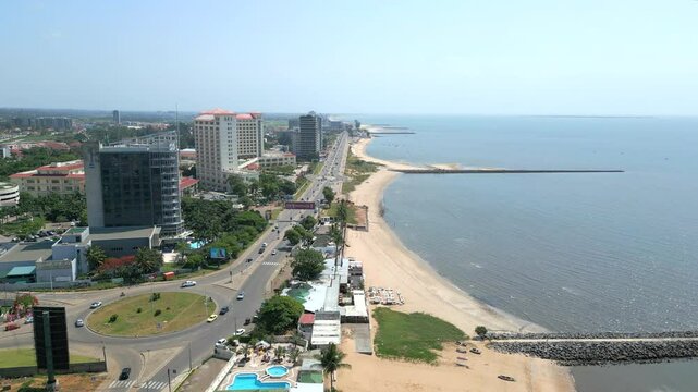 Maputo, Mozambique - The Breathtaking Coastal Scenery Highlights Sleek Modern Buildings and a Tranquil Shoreline - Aerial Pullback Shot