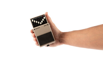 Male hand holding grey guitar effects pedal isolated on white background cutout