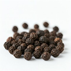 Obraz premium A scattering of black peppercorns, isolated on a white background with a shallow depth of field.