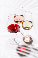 Three wine glasses filled with red, white, and rose wine
