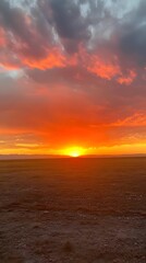 Fototapeta premium A vibrant sunset sky over an empty field with no structures in sight