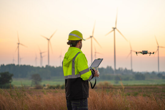 Engineer Specialists Pilot Drone on Wind Turbine Farm. Architectural Engineer and Safety Engineering Inspector Fly Drone at industrial plant.