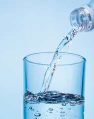 Crystal clear water being poured into a transparent glass, creating refreshing ripples and bubbles