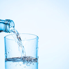 Crystal clear water being poured into a transparent glass, creating refreshing ripples and bubbles