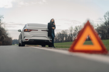Woman waiting for roadside assistance after car breakdown