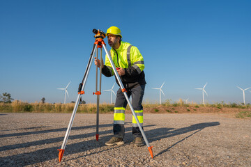 Engineer wearing uniform inspection and survey work in wind turbine farms rotation to generate electricity energy. Maintenance engineer working in wind turbine farm at sunset.