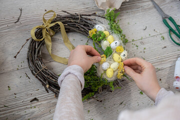 Handmade Easter wreath festive yellow egg decorations. Traditional holiday preparation craft master class of creative making decor. Hands-on activities sustainable responsible holiday gift workshop