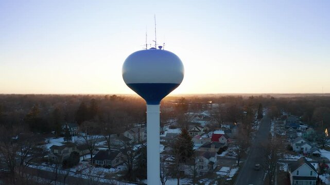 Golden Hour Aerial Footage of Columbus Junction Water Tower and Suburban Landscape in Winter
