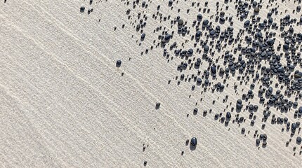 Aerial View of Black Stones Spread Across Sandy Beach in Warm Light. generator AI