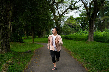Fototapeta premium Man Jogging Along a Curved Path in a Peaceful Green Park