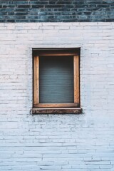 Wooden window framed against a weathered white brick wall, highlighting urban architecture and design in a serene, minimalist setting in daylight
