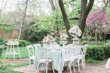 Obraz premium Springtime Tea Party A garden tea party setup with delicate porcelain teacups, floral arrangements, and pastel-colored pastries.