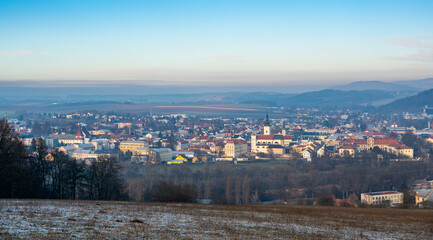 Aerial view of Moravska Trebova with its scenic panorama. The town is surrounded by rolling hills and dense forests, showcasing the harmony of historic architecture and Czech nature