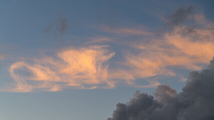 Mixed orange and gray clouds on a blue sky in Israel.

