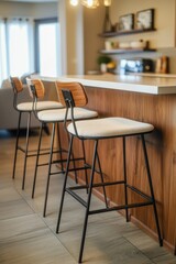 This is a modern kitchen scene featuring a dining area with wooden counters and bar stools. The island in the center serves as both a preparation space and additional seating.