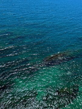 Blue turquoise shiny sea water surface aerial view.