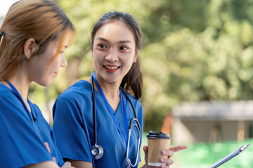 Doctors enjoying a break, conversing with coffee and a clipboard.