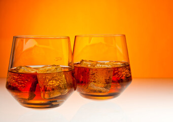 Two tumblers with whiskey on the rocks