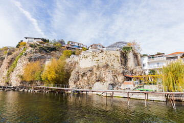 Scenic view of houses built on a cliffside, overlooking a body of water with a wooden pier...