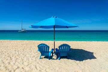 Two blue beach chairs and parasols in Meads Bay beach, Caribbean dream and landscape, Anguilla island, British West Indies © Delphotostock