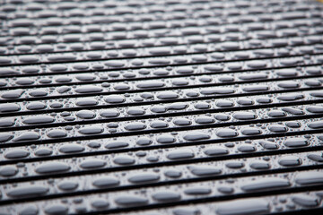 Accumulation of large water drops on black metal bar - Background pattern