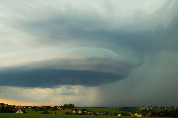 A huge, dark shelf cloud or  Cumulonimbus (Cb) drifts across the meadow in Lower Bavaria, Germany