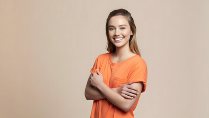 Obraz premium Side view young smiling Caucasian woman she wear orange shirt casual clothes hold hands crossed folded look camera isolated on plain pastel light beige background studio portrait