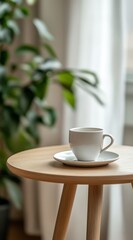 White coffee cup on wooden side table near plant.