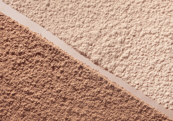 Sculptor or two colors of compact powder brown and beige nude smudge textured background diagonal...