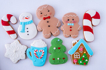 Gingerbread man decorated with white sugar glaze. Food background. Christmas tree winter cookies different set. Snowman cane cup house