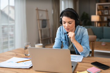 Young freelance businesswoman attending online educational class on laptop computer webcam...