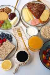 Assortment of various breakfast foods and drinks on the white table. Selective focus.