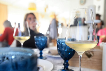 a glass of white wine served in a restaurant, abstract background of a summer restaurant