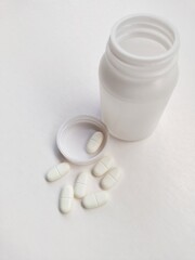 Pills and bottle over white background. 